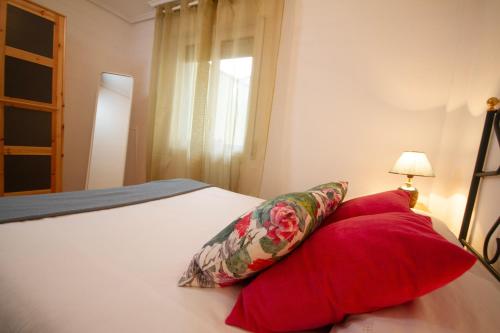 a bedroom with a bed with two red pillows at Los Respigos Ampuero in Ampuero