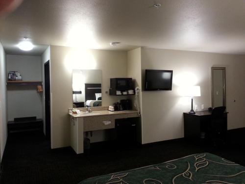a hotel room with a sink and a mirror at Travelodge by Wyndham McAlester in McAlester
