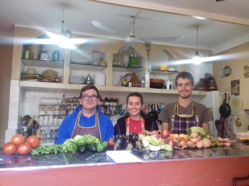 tres personas de pie detrás de un mostrador con frutas y verduras en For You Riad Marrakech en Marrakech