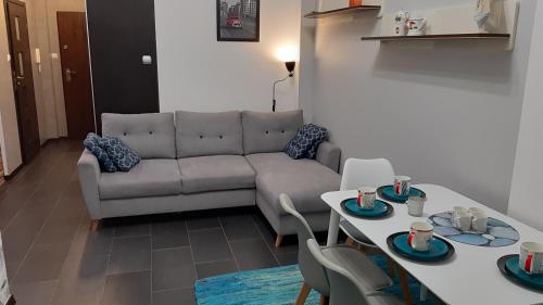 ギジツコにあるApartament Twoja Przystańのソファとテーブルのあるリビングルーム