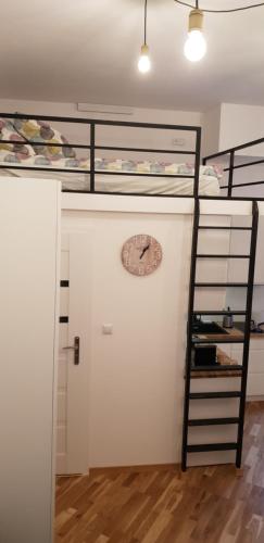 a room with two bunk beds and a clock on a wall at Apartment Lenartowicza in Krakow