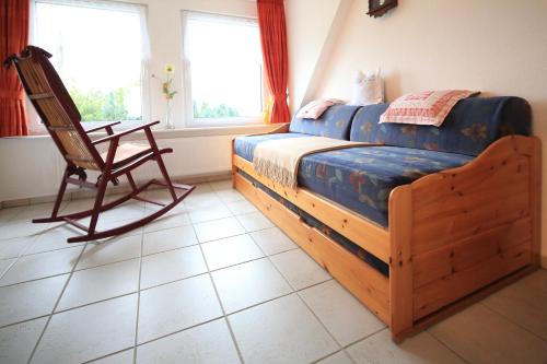 a bedroom with a wooden bed and a rocking chair at Ferienwohnung Thien in GroÃŸ Niendorf