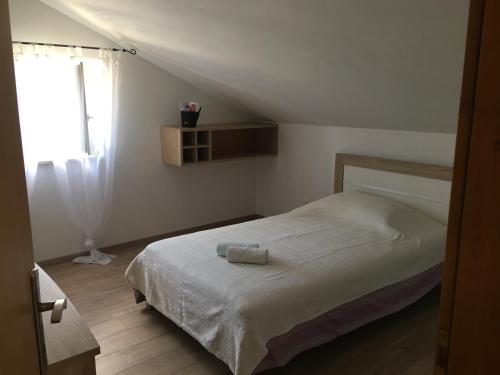 a bedroom with a bed and a window at Villa Belvedere Žiža in Donji Humac