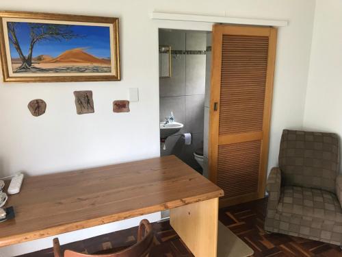 a room with a wooden table and a bathroom at Towerzicht Guest House in Ladismith