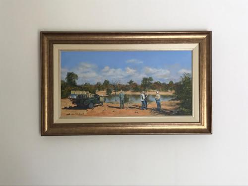 a framed painting of three men and a truck at Towerzicht Guest House in Ladismith