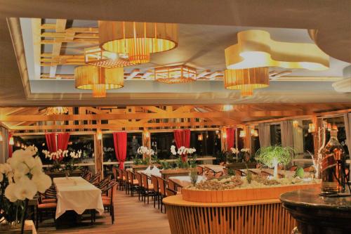 a dining room with tables and chairs and chandeliers at Leipziger Hotel in Leipzig