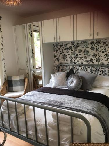 a bedroom with a bed with a black and white headboard at Mo-Dhachaidh B&B in Poolewe