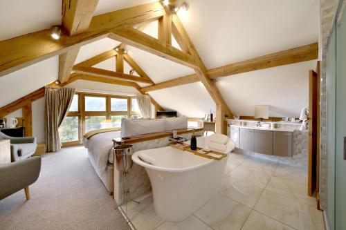 ein Bad mit einer Badewanne und einem Waschbecken in einem Zimmer in der Unterkunft A Barn at South Downs Stay in Houghton