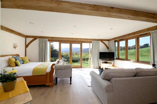 a bedroom with a bed and a couch and a tv at A Barn at South Downs Stay in Houghton