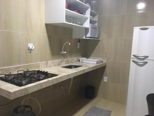a kitchen counter with a stove and a sink at Pousada Belo Recanto - Pipa in Pipa