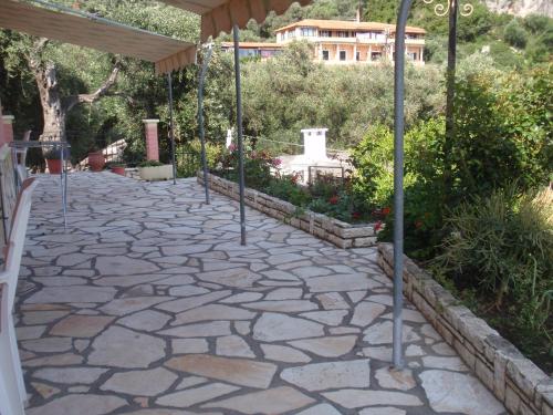 a stone walkway with poles in a garden at Korina Studios in Paleokastritsa