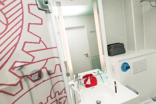 a bathroom with a toilet and a sink and a mirror at ibis Styles Paris Mairie De Clichy in Clichy