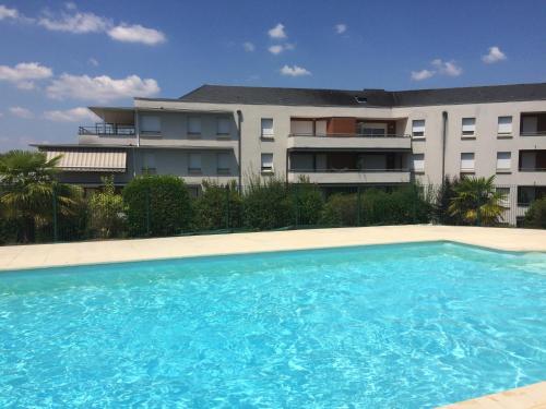 une grande piscine en face d'un bâtiment dans l'établissement Résidence CAP HORIZON, à Brive-la-Gaillarde