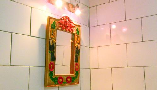a mirror on a wall in a bathroom at La Palapa Hut Nature Hostel in Puerto Jiménez
