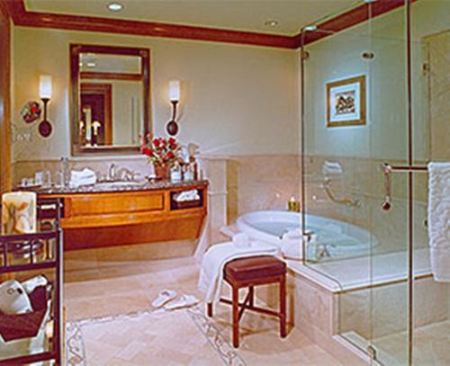 a bathroom with a tub and a sink and a shower at The Rose Hotel in Pleasanton
