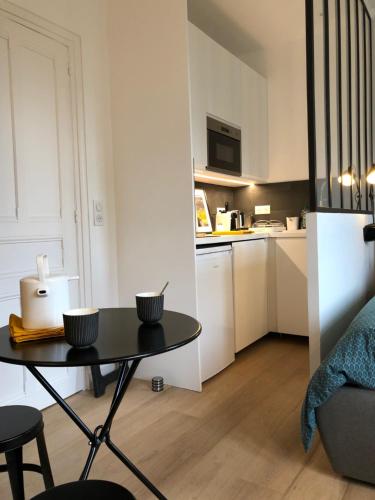 Ce petit appartement comprend une table et une cuisine. dans l'établissement Deauville centre, plage, casino et hippodrome, à Deauville
