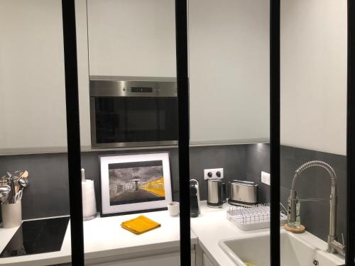 une cuisine avec un évier et une photo sur un comptoir dans l'établissement Deauville centre, plage, casino et hippodrome, à Deauville