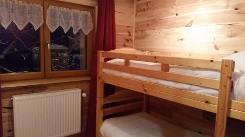 een slaapkamer met 2 stapelbedden in een blokhut bij Chalet des Bruyères in La Bresse