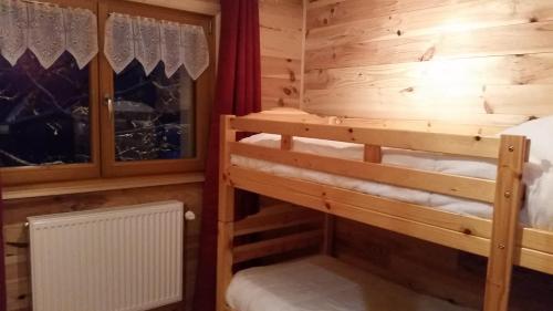 a bedroom with two bunk beds in a log cabin at Chalet des Bruyères in La Bresse