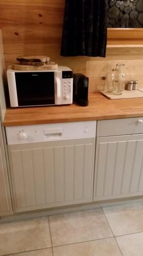 un micro-ondes posé sur un comptoir dans une cuisine dans l'établissement Chalet des Bruyères, à La Bresse