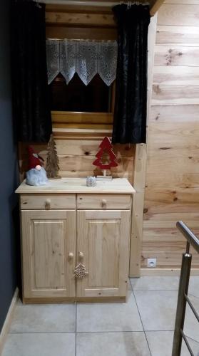 La salle de bains est pourvue d'un lavabo en bois et d'une fenêtre. dans l'établissement Chalet des Bruyères, à La Bresse