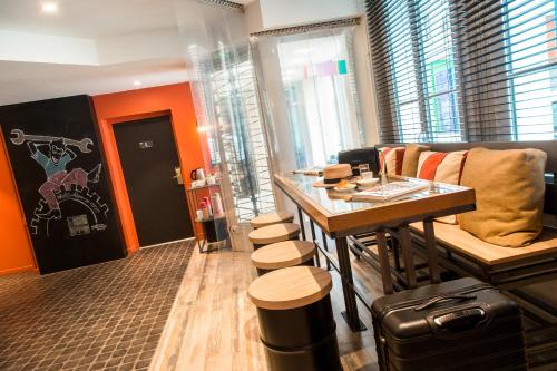 a room with a bar with stools and a table at ibis Styles Paris Mairie De Clichy in Clichy