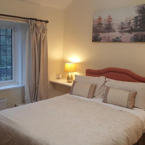 a bedroom with a large white bed with a window at Dragon Bed and Breakfast in Betws-y-coed