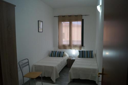 una habitación con dos camas y una ventana en Sa Domo de Mannoi, en Orosei