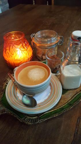 a bowl of coffee sitting on a plate with a spoon at Een vleugje wellness in de Voerstreek - Bed & Brocante Onder de Poort in Voeren