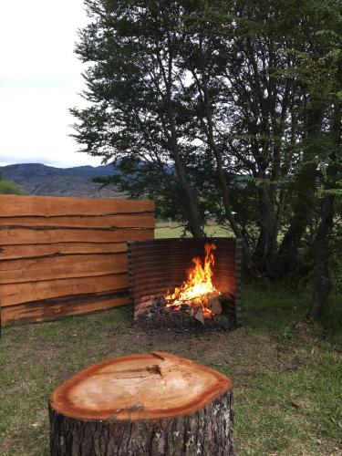 a fire pit with a tree stump in front of it at Ribera Cochrane, Cochrane in Cochrane