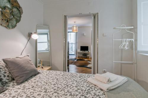 een slaapkamer met een bed en een spiegel bij Alfama Apartment in Lissabon