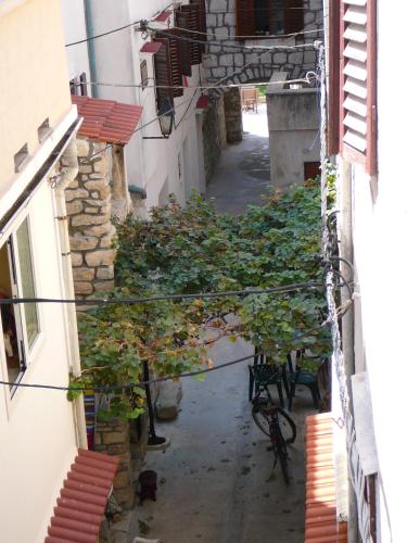 an alley way between two buildings with trees and chairs at Moon Stone Residence Pag in Pag