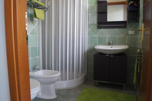 a bathroom with a toilet and a sink and a shower at Sa Domo de Mannoi in Orosei