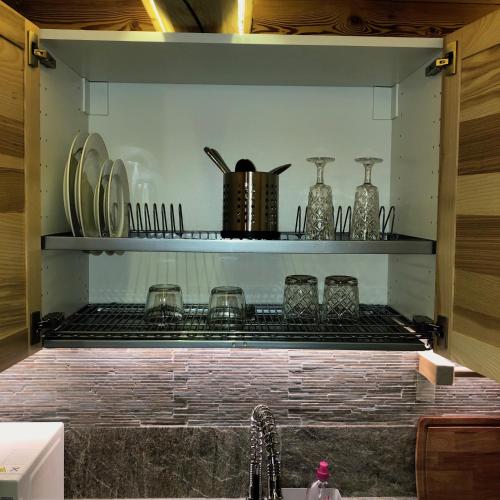 une cuisine avec des assiettes et des verres sur une étagère dans l'établissement Le joli nid, à Les Deux Alpes