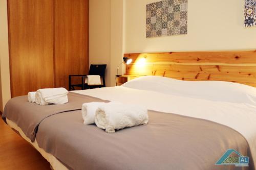 a bedroom with two white towels sitting on a bed at " Arco da Fajã" For 7 max in Ponta Delgada