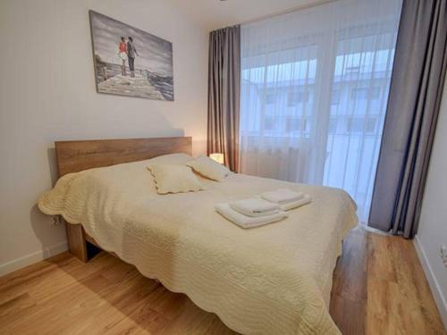 ein Schlafzimmer mit einem Bett mit zwei Handtüchern darauf in der Unterkunft Apartament Bliżej Morza in Kołobrzeg