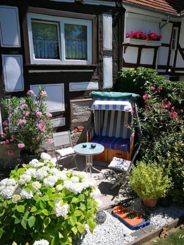 a patio with a chair and flowers in front of a house at Ferienwohnung Misch in Eschwege