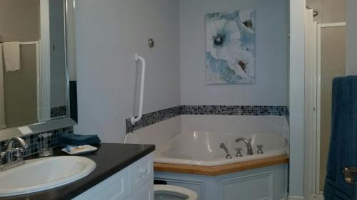 a bathroom with a white tub and a sink at Condo Lac Archambault 295 in Saint-Donat-de-Montcalm