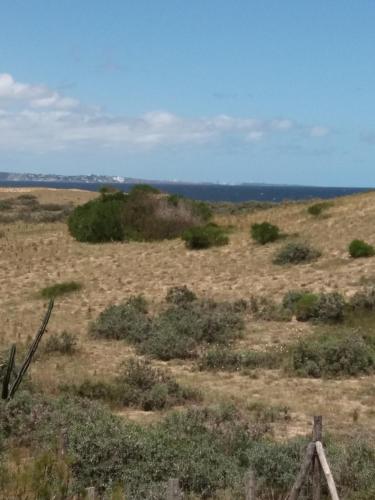 a field with a fence in the middle of a field at Aroma de mar casas en alquiler vacacional con hermosa piscina in Sauce de Portezuelo