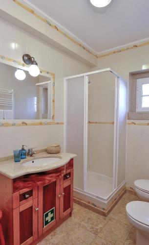 a bathroom with a shower and a sink and a toilet at Villa over the Ocean in Magoito-Sintra in Sintra