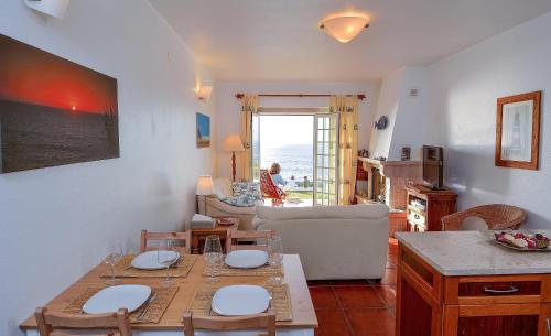 Una cocina y una sala de estar con mesa y sillas. en Villa over the Ocean in Magoito-Sintra, en Sintra