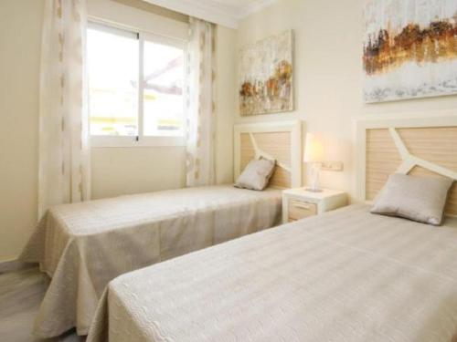 1 dormitorio con 2 camas y ventana en Dama de Noche, en Marbella