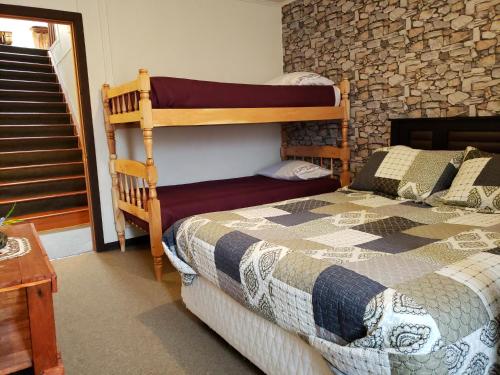 Hostal Torres del Paine 2 في بونتا أريناس: غرفة نوم مع سرير بطابقين وجدار حجري