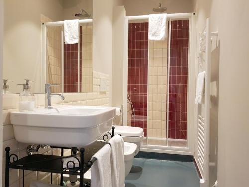 a white bathroom with a sink and a toilet at Almarossa in Bologna