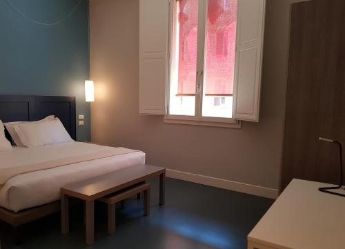 a hotel room with a bed and a window at Almarossa in Bologna