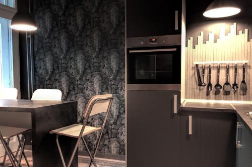 eine Küche mit Theke und Tisch mit Stühlen in der Unterkunft Design Atelier in Sarajevo