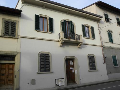 Edificio blanco con persianas negras y balcón en Gelsomino 74, en Florencia