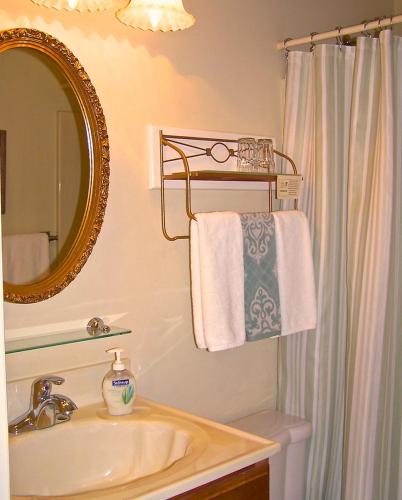 a bathroom with a sink and a mirror and towels at Lyndon House Bed & Breakfast in Lexington