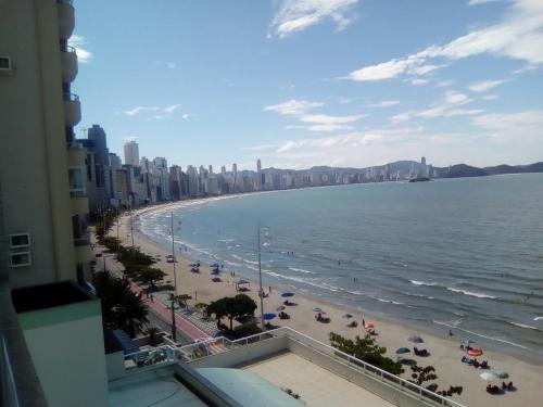 a view of a beach with umbrellas and the ocean at Apartamento frente ao mar in Balneário Camboriú