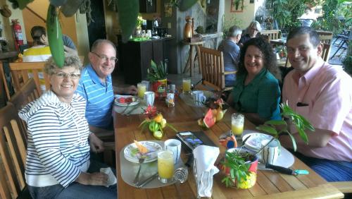 a group of people sitting around a wooden table at Pura Vida Hotel in Alajuela City